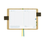 Open Hobonichi A6 planner displaying July grid daily layouts inside floral cover