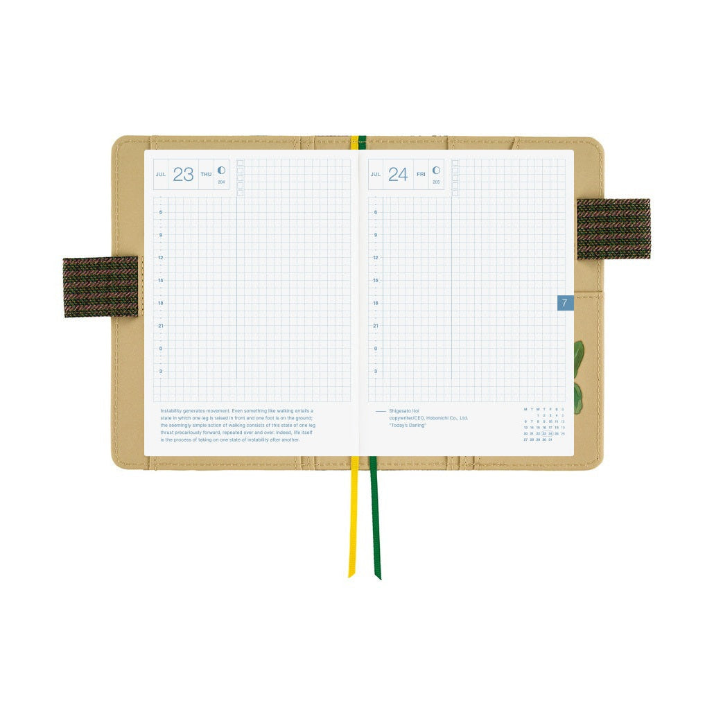 Open Hobonichi A6 planner displaying July grid daily layouts inside floral cover