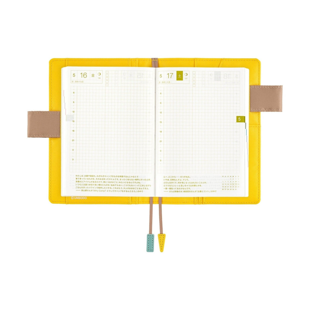 Yellow Hobonichi A6 planner open with butterfly pen holders and grid pages