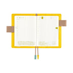 Yellow Hobonichi A6 planner open with butterfly pen holders and grid pages