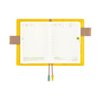 Open Hobonichi Techo A6 planner showing grid daily pages and butterfly pen holders