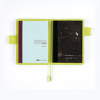 Open Hobonichi Graph Notebook A6 with lime green cover and night cat illustration