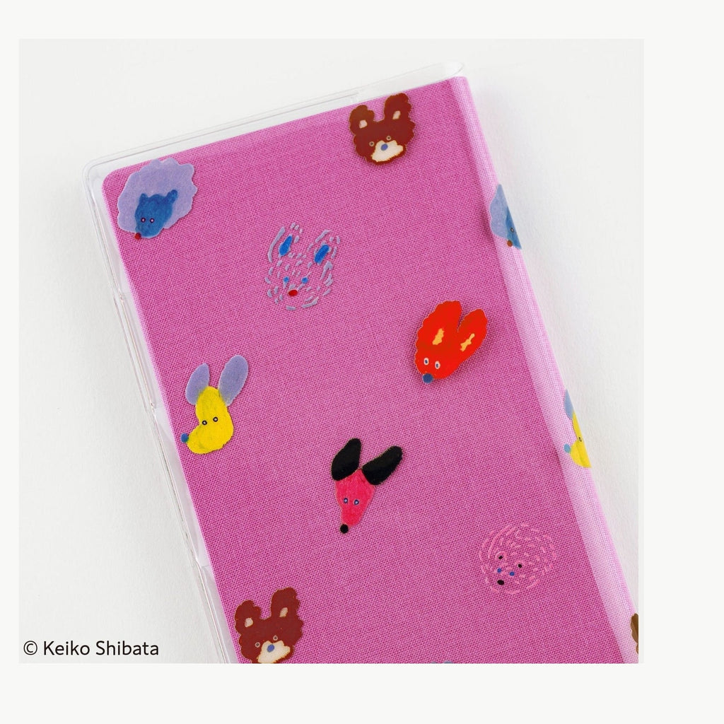 Close-up of pink Hobonichi planner with clear dog ears fluttering protective sleeve