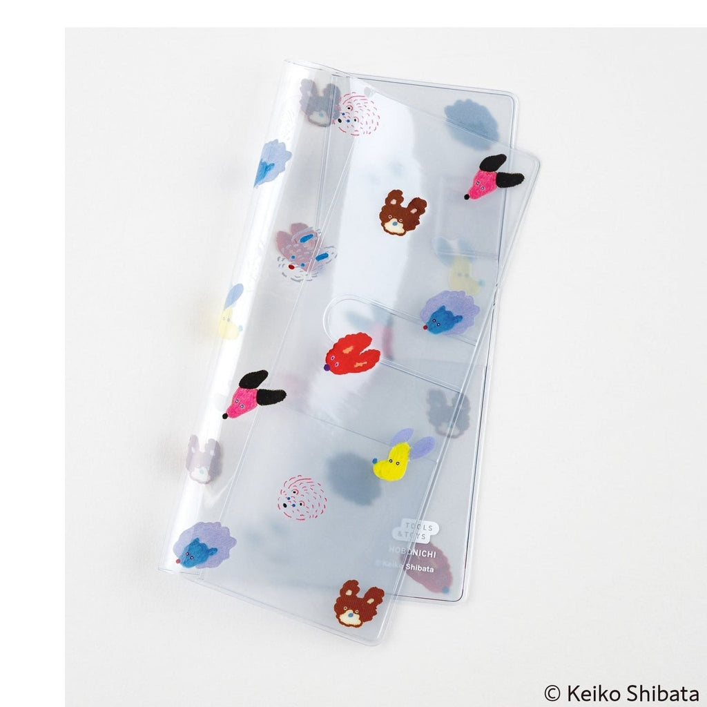 Transparent Hobonichi planner cover showing seven colorful dog illustrations and cutouts
