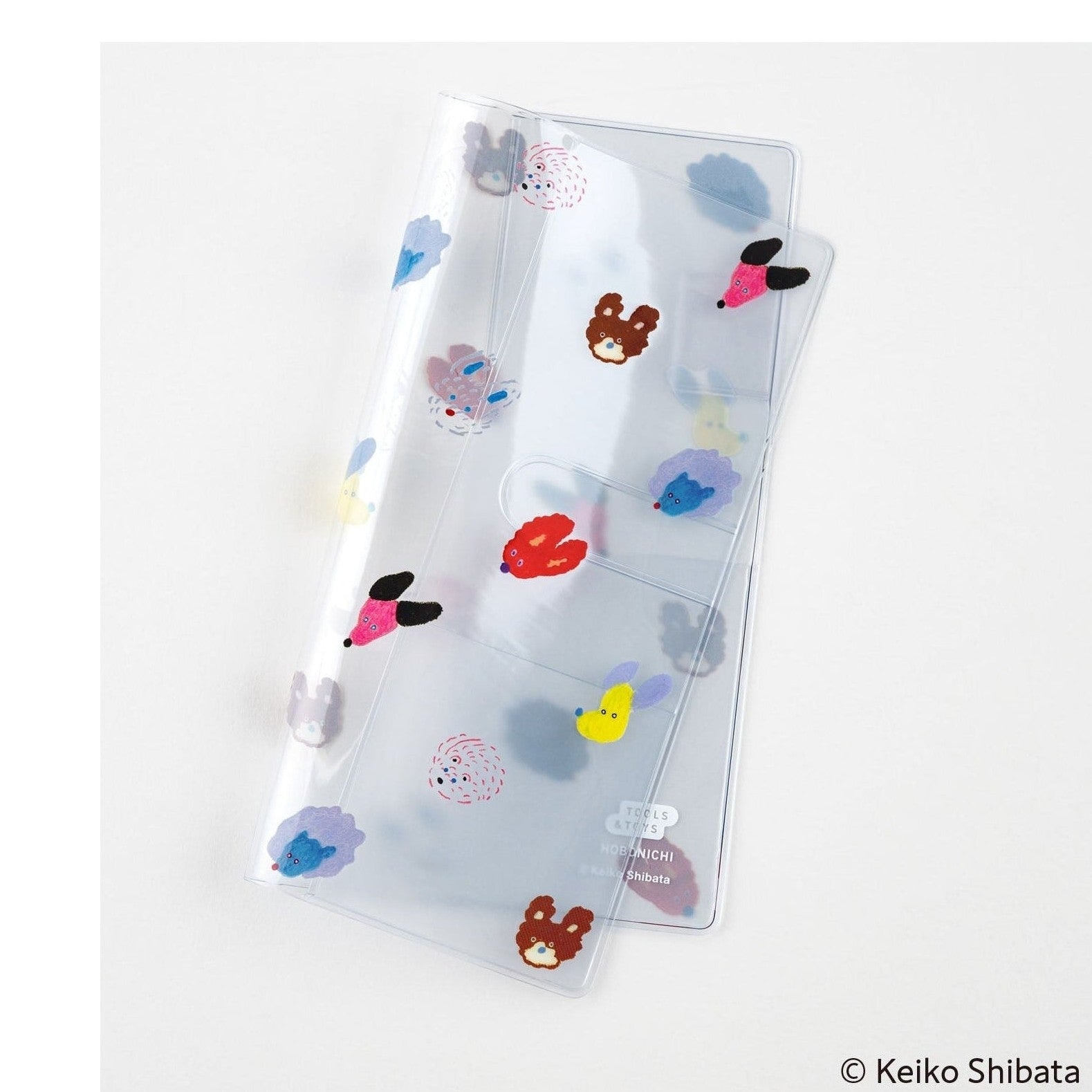 Transparent Hobonichi planner cover showing seven colorful dog illustrations and cutouts