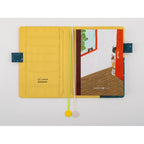 Open Hobonichi Techo notebook showing yellow pockets and ribbon bookmarks