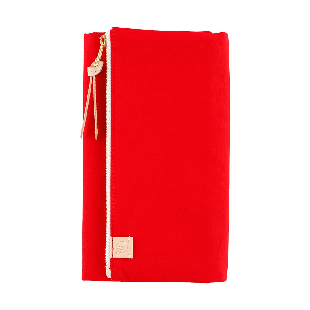 Closed red Hobonichi cover with vertical zipper and leather tag