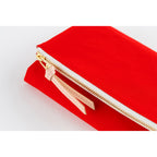 Detail shot of red cover edge with gold zipper teeth and leather pull