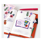 Hobonichi Techo sticky note tabs with Yumi Kitagishi illustrations on grid notebook
