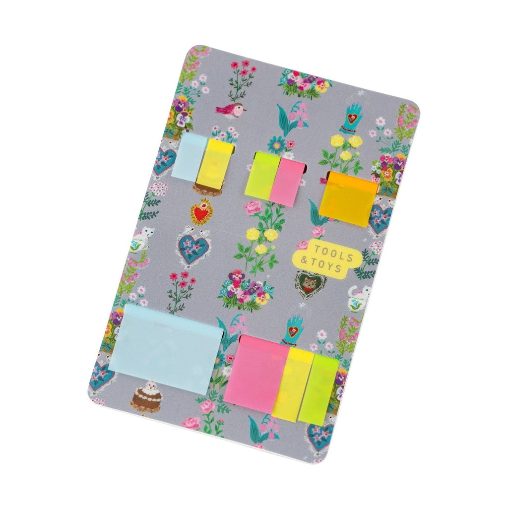 Hobonichi Techo Yumi Kitagishi translucent sticky notes with floral motif and pastel colors in gray holder