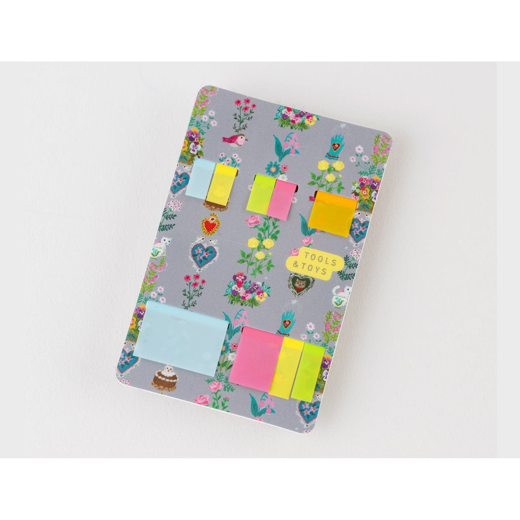 Top-down view of Yumi Kitagishi floral sticky note holder with pastel translucent notes