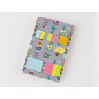 Top-down view of Yumi Kitagishi floral sticky note holder with pastel translucent notes