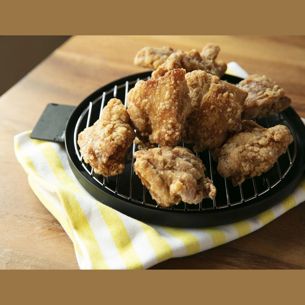 Fried chicken served on black iron pot lid with wire rack