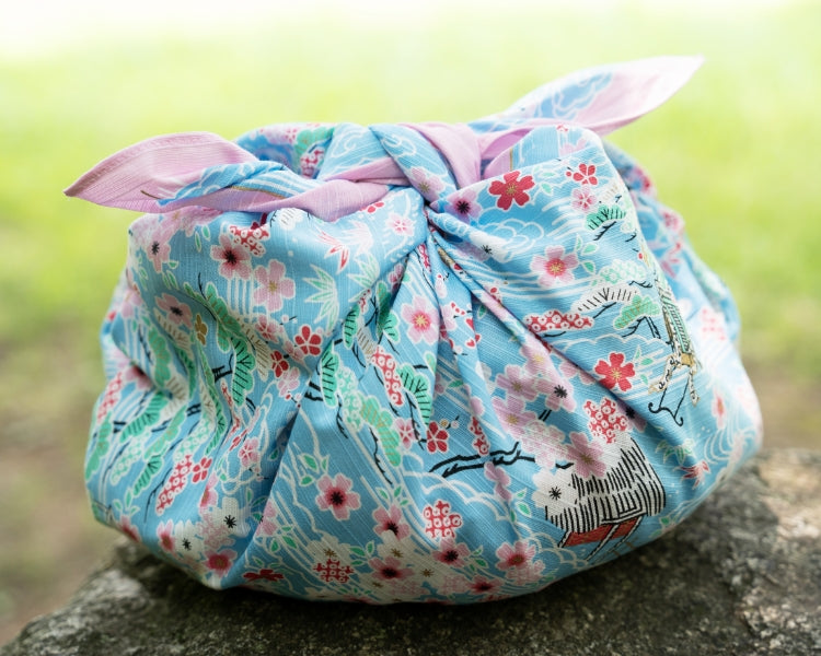 Kashiko Sakura Kasumi light blue furoshiki tied as a pouch with cherry blossom pattern
