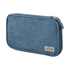 Beige corduroy Kokuyo Pancase open with stationery organized in dual compartments alongside yellow blue and gray cases