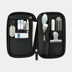 Open black Kokuyo Pancase pencil case with dual panels holding pens, compass, and dog tag chain