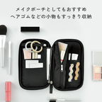 Black fabric Kokuyo Pancase used as makeup pouch with hair ties and brushes in zippered pockets