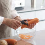 Marna black Y-shaped vegetable peeler slicing carrot in kitchen