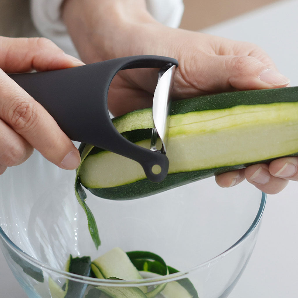 Black Marna Y-peeler creating continuous zucchini strips