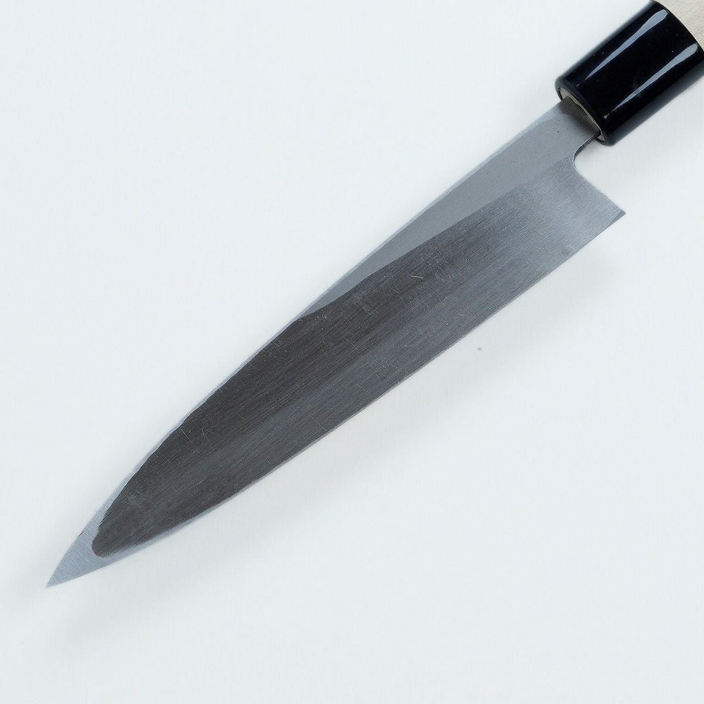 Close-up of polished steel bevel and black ferrule on Mikihisa knife