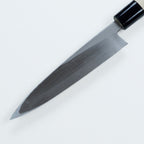 Close-up of polished steel bevel and black ferrule on Mikihisa knife