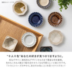 Assorted Minoru Toiro ceramic dishes in various shapes and earth tones on wooden tray