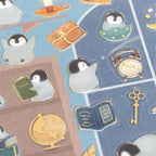 Close-up of gold foil penguin stickers on transparent PET backing
