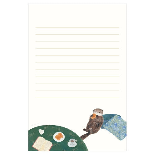 Otter eating madeleine at cafe table stationery design on cream lined letter pad