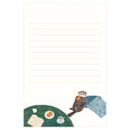 Otter eating madeleine at cafe table stationery design on cream lined letter pad