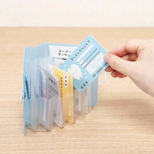 Hand inserting card into open light blue accordion document folder
