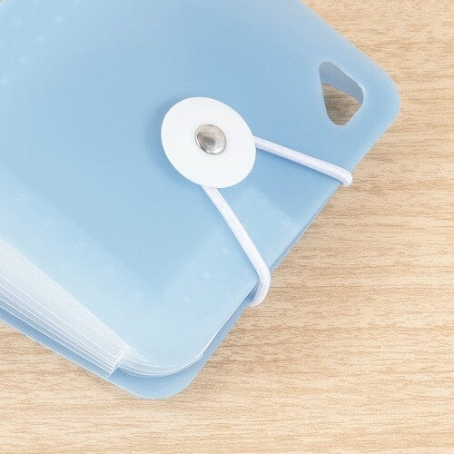 Close-up of white elastic cord and snap fastener on blue folder