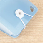 Close-up of white elastic cord and snap fastener on blue folder