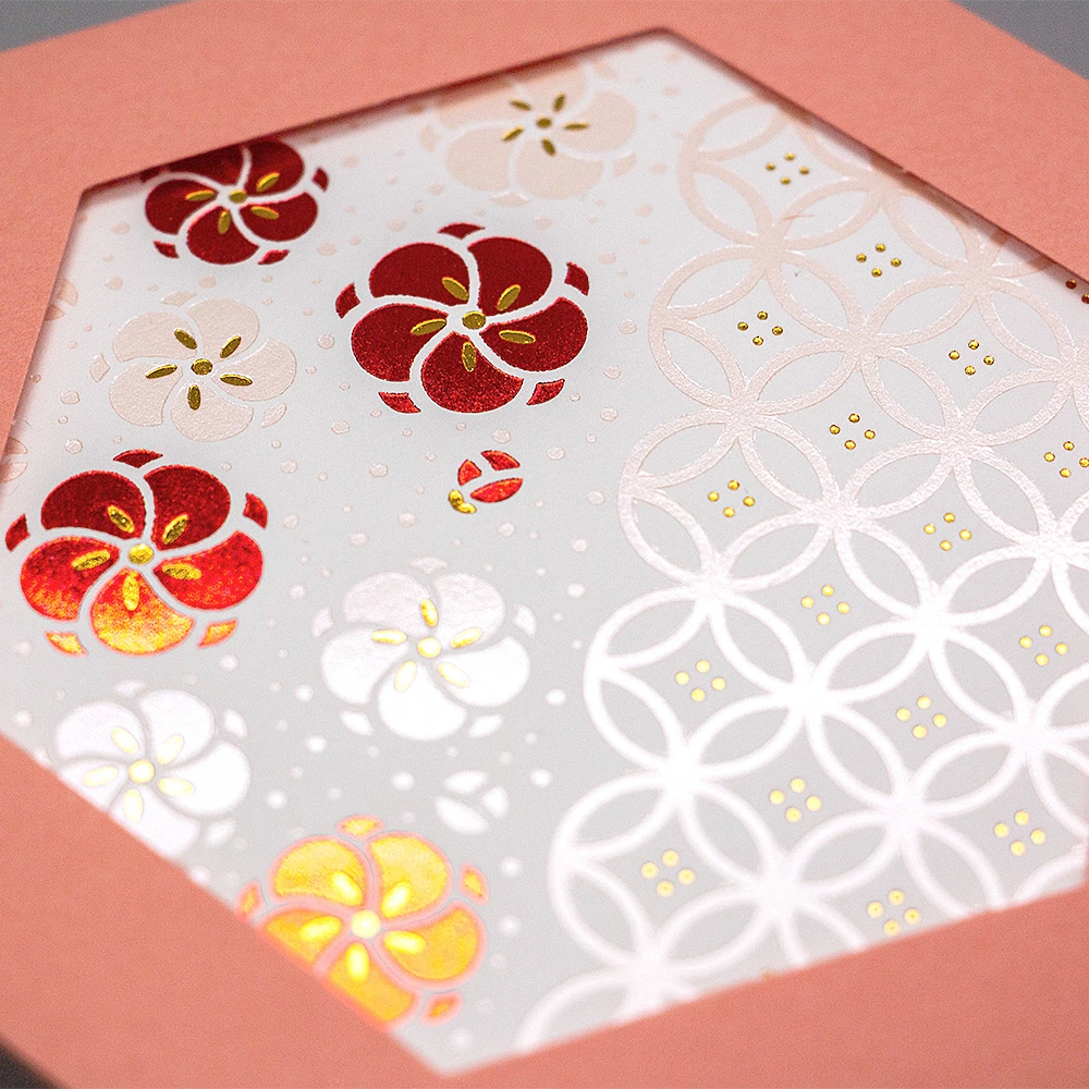 Close-up of foil-stamped plum blossom details on hexagon card