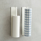 White Shimoyama adhesive paper towel holder holding two rolls on gray wall