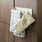 Versatile white Shimoyama wall mount holding checkered cloth and oven mitt on cabinet