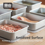 Anodized aluminum food storage containers holding raw meat on wooden surface