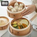 Two-tier Shimoyama bamboo steamer cooking dumplings and vegetables
