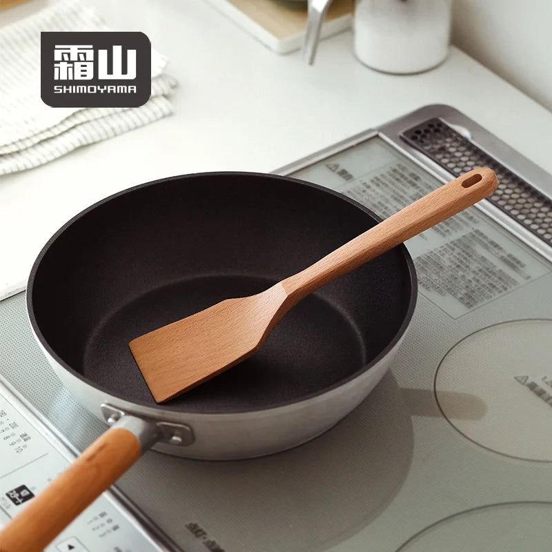 Shimoyama Beech Square Frying Spatula 26cm resting in non-stick pan