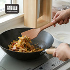 Stir-frying vegetables and meat with square beech spatula in wok