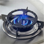 Black cast iron trivet stabilizing small pot on gas stove burner