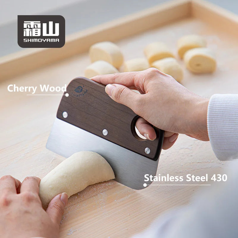 Close-up of Shimoyama bench scraper using cherry wood handle and 430 stainless steel blade to portion dough
