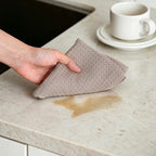 Taupe waffle weave cotton cloth wiping countertop spill