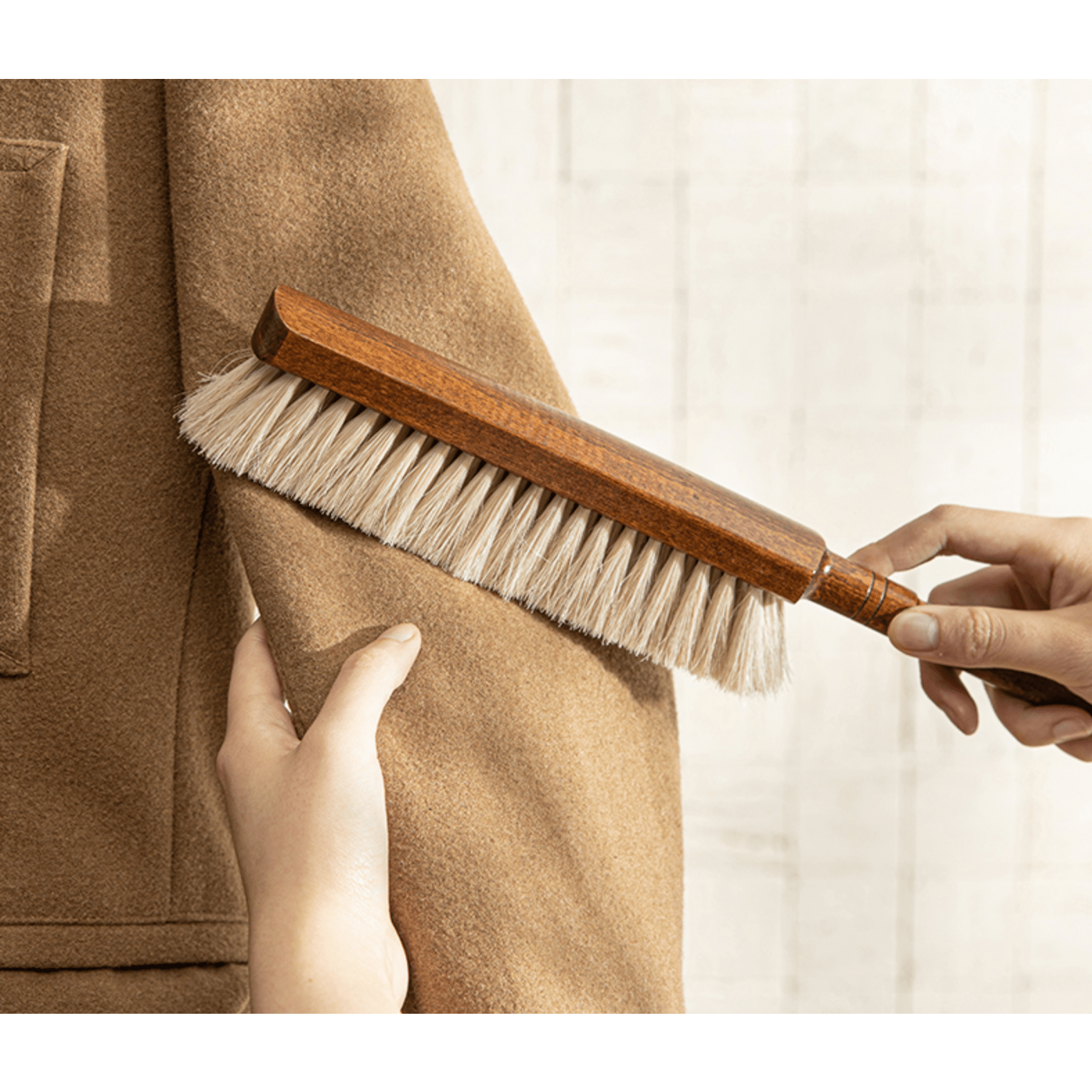 Using natural horsehair brush on wool garment sleeve
