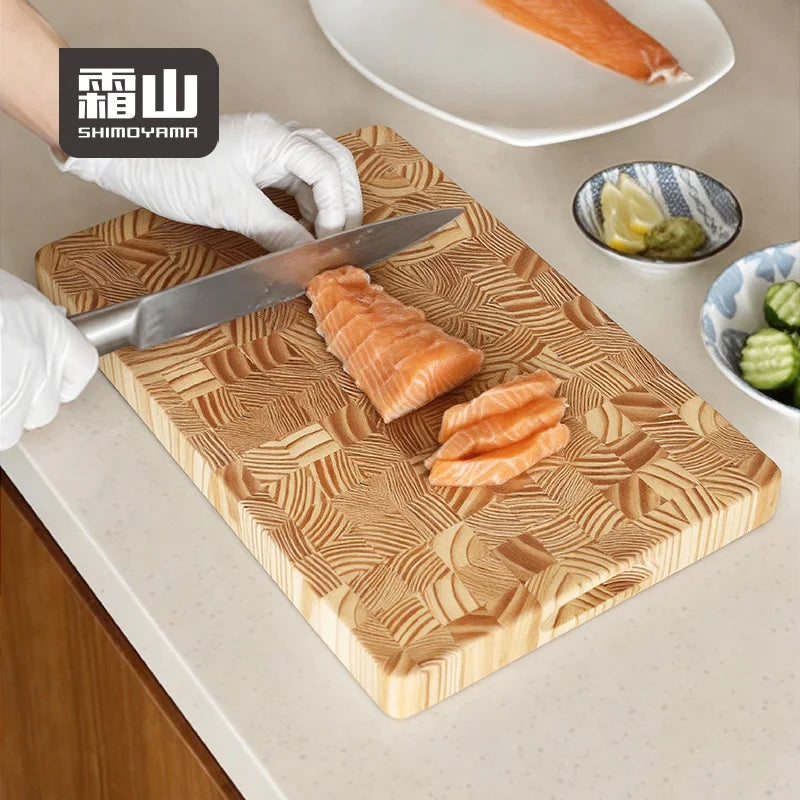 Slicing salmon on thick end-grain wooden chopping board