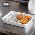 Shimoyama stainless steel wave oil drain rack holding fried croquettes in white tray