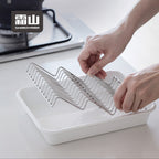 Hands placing Shimoyama wave drain rack into serving tray for cooking use