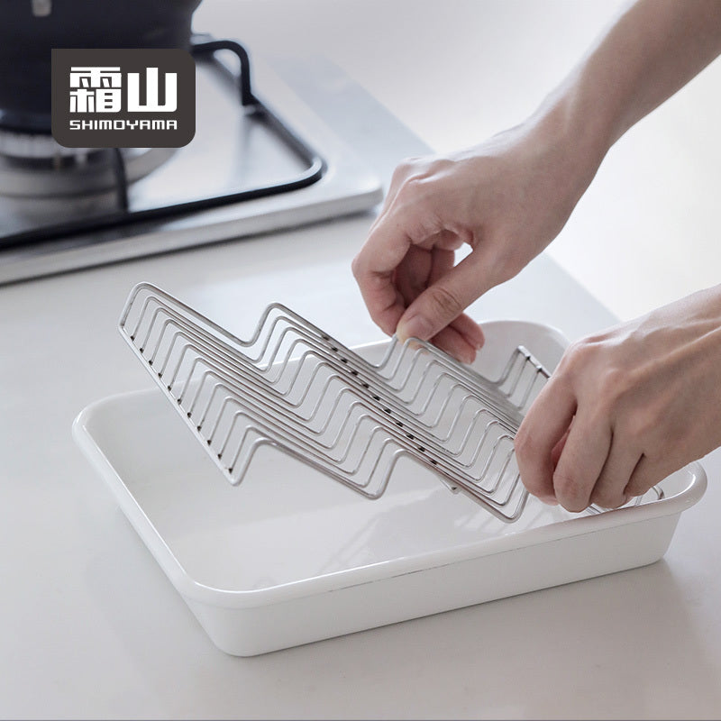 Hands placing Shimoyama wave drain rack into serving tray for cooking use