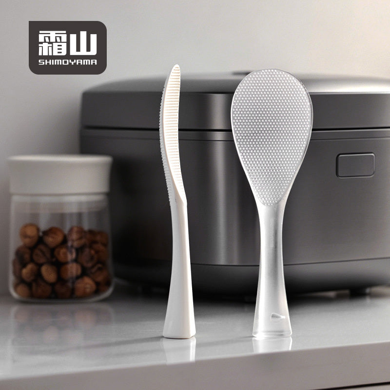 Clear textured TPX rice paddle standing upright on counter