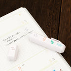One Totonofu stamp twisted off its stick beside a planner