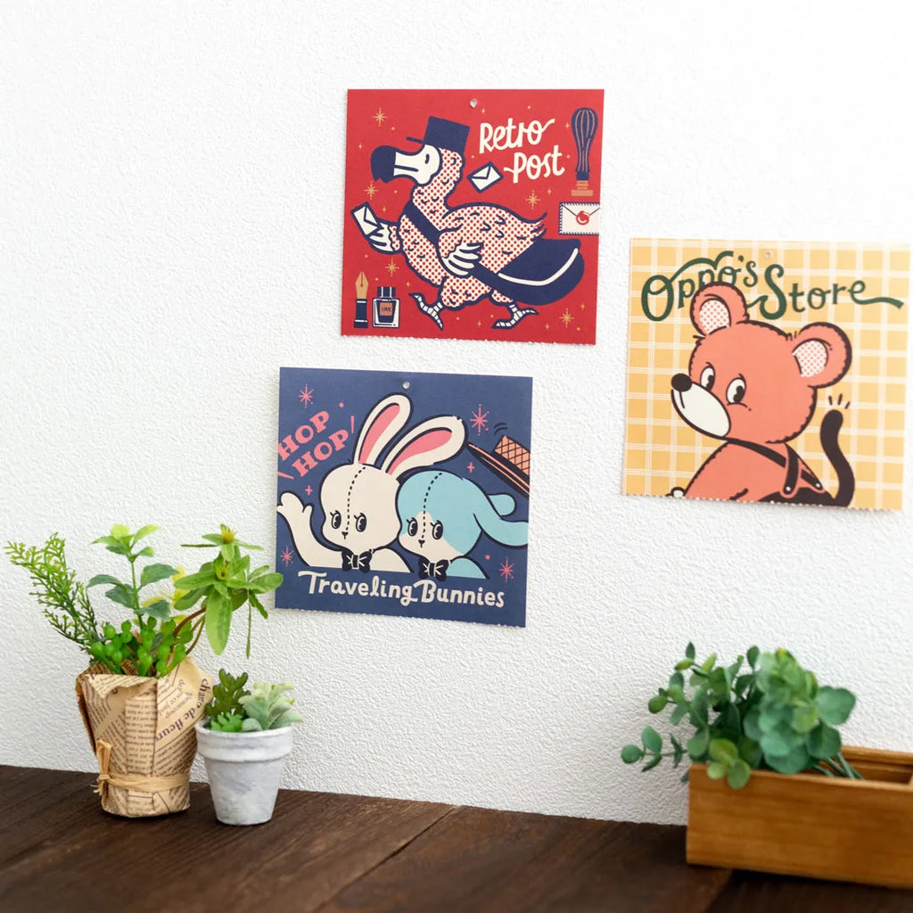 Three artworks from the ob1toy Mini Wall Calendar 2027 pinned to a wall
